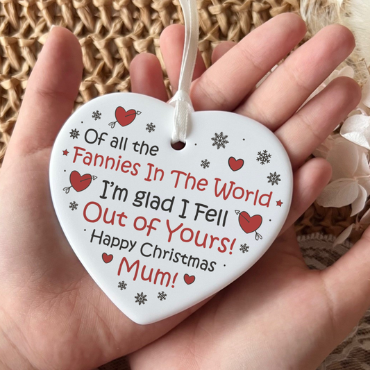 Heart-shaped ornament with text held in a hand against a textured background