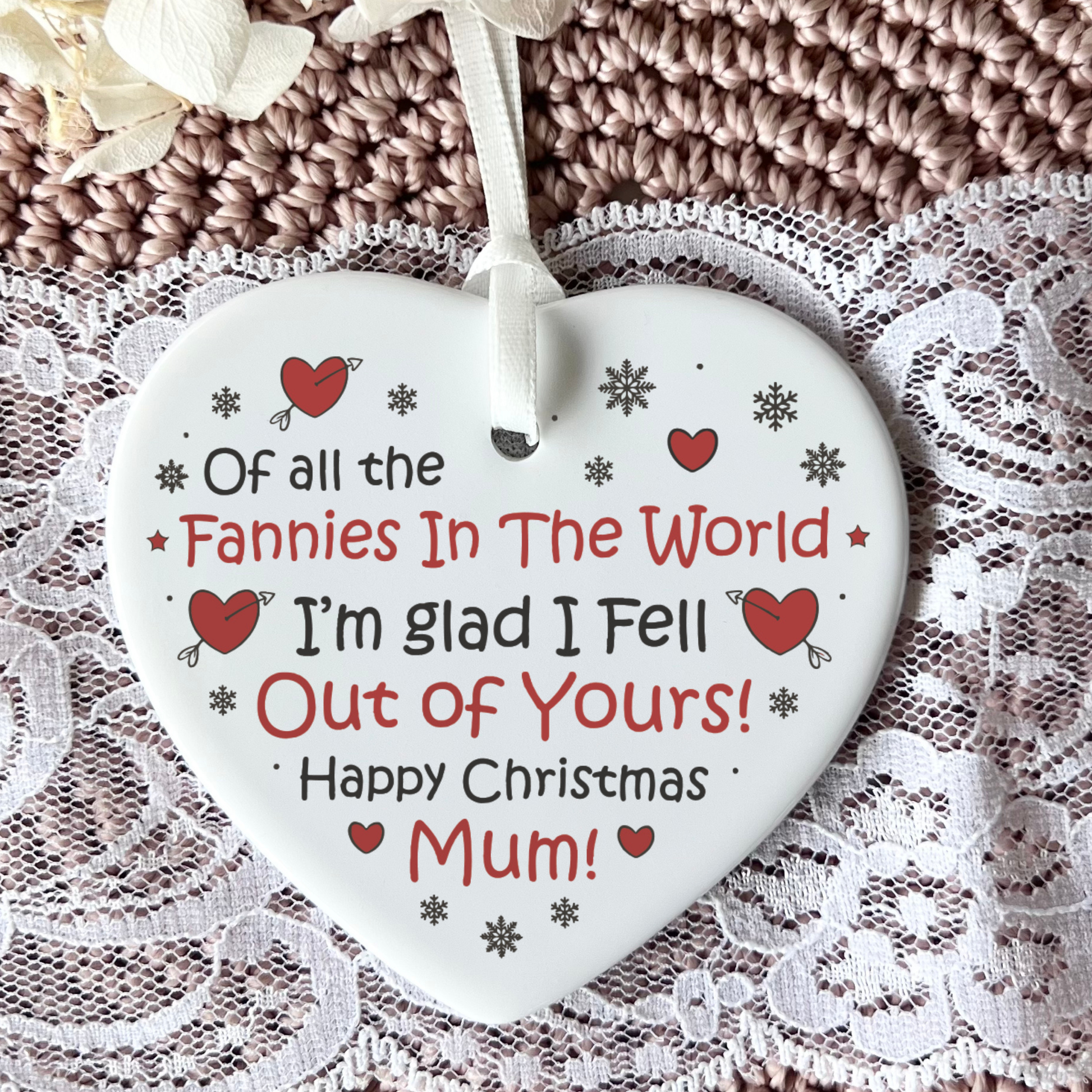 Heart-shaped Christmas ornament with a humorous message on a lace background