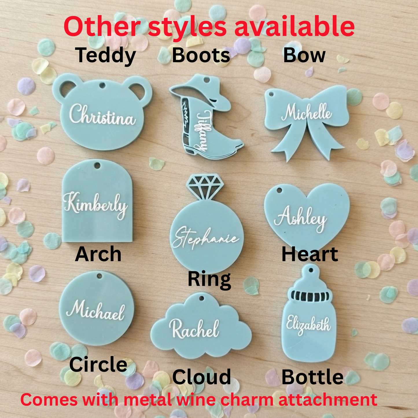 A flat-lay product display showing multiple pastel blue personalized baby keepsake charms on a light wood background with confetti. Red text at the top and bottom reads 'Other styles available' and lists styles like Teddy, Boots, Bow, plus names and shape names such as Christina, Kimberly, Arch, Stephanie, Ring, Ashley, Michael, Circle, Rachel, Michelle, and Elizabeth.