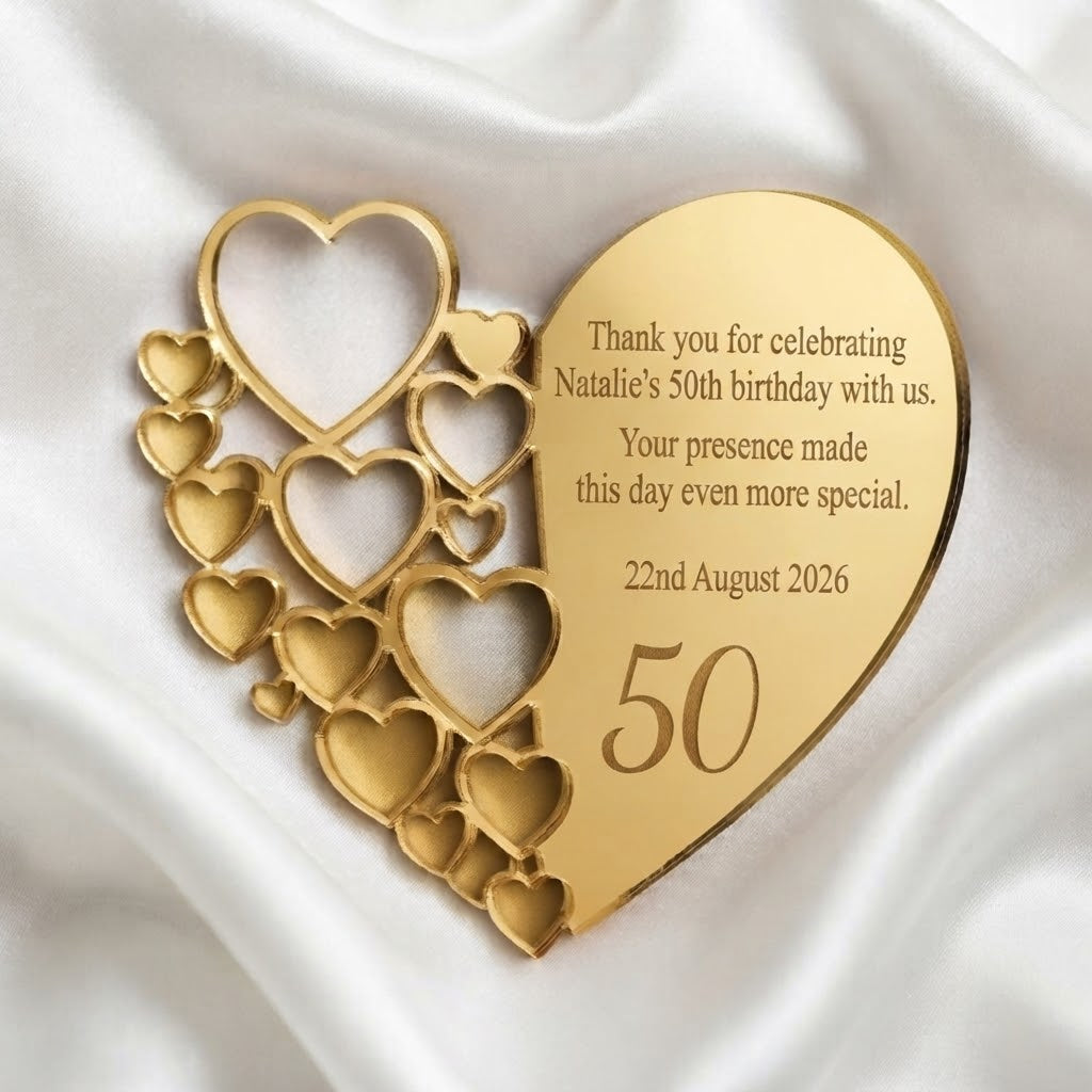 A personalized gold heart-shaped 50th birthday plaque with a collage of heart cutouts on one side and a smooth engraved side reading 'Thank you for celebrating Natalie's 50th birthday with us. Your presence made this day even more special.