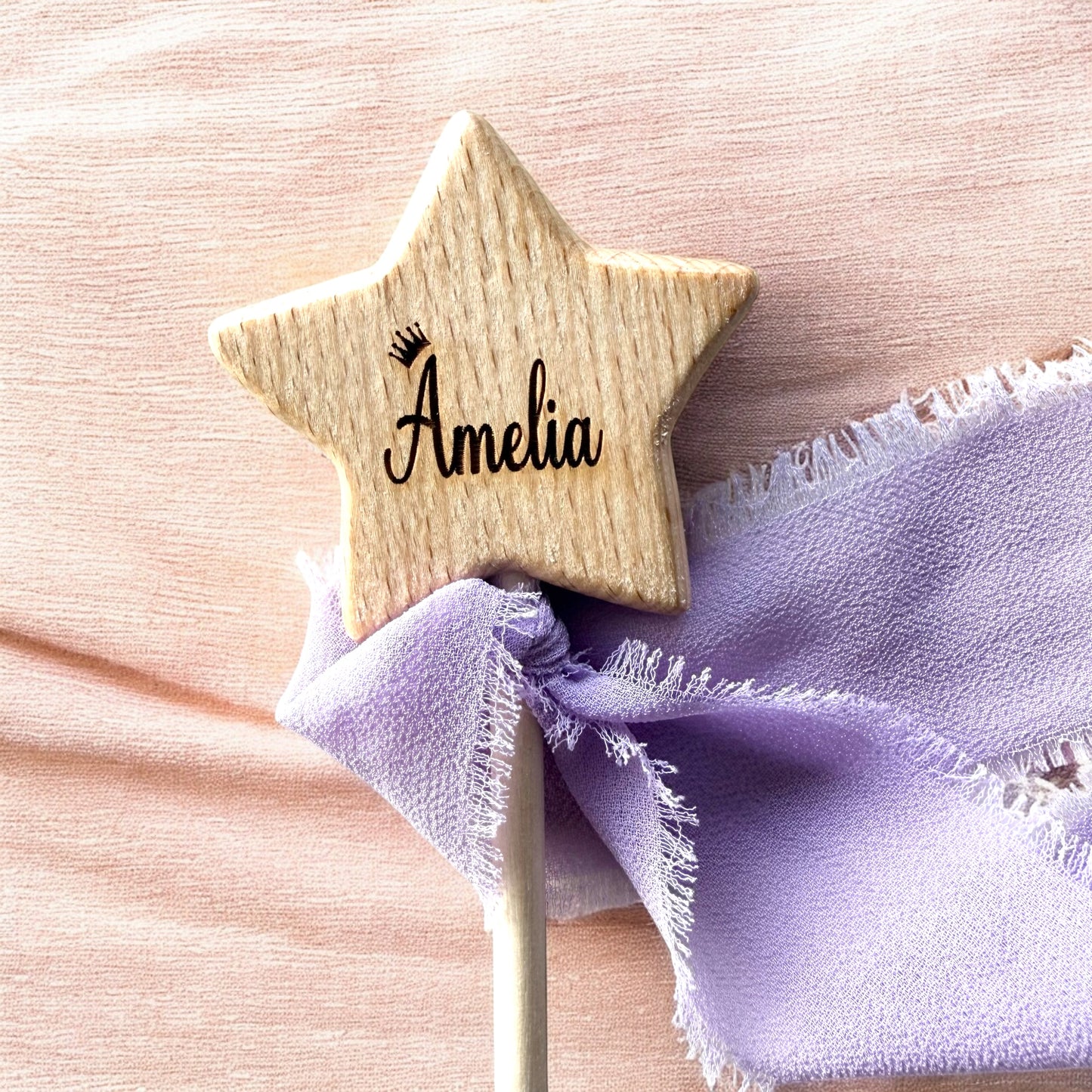 Wooden star-shaped name tag with 'Amelia' on a pink background