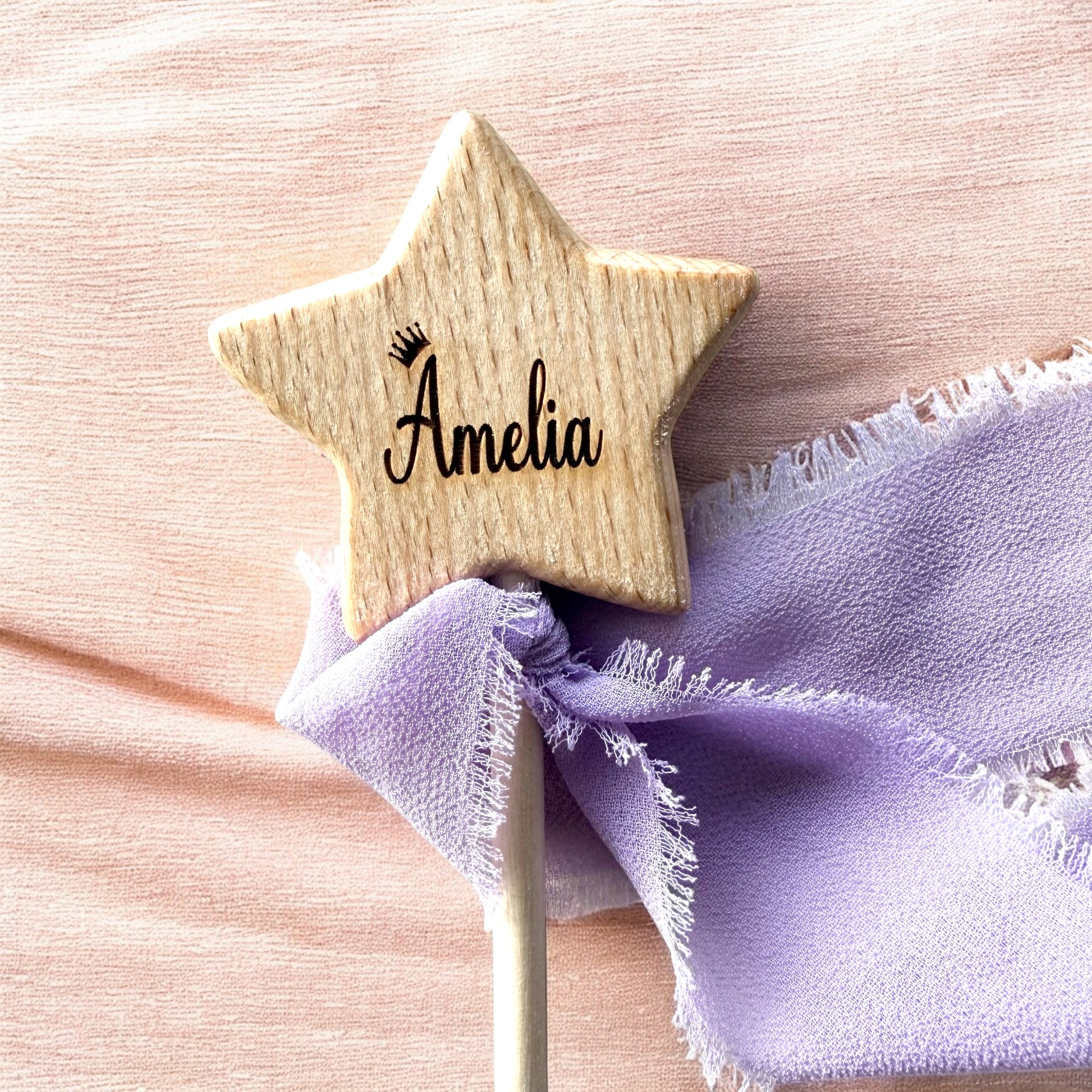 Wooden star-shaped name tag with 'Amelia' on a pink background